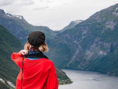 Girl in red jumper looking over a valley.